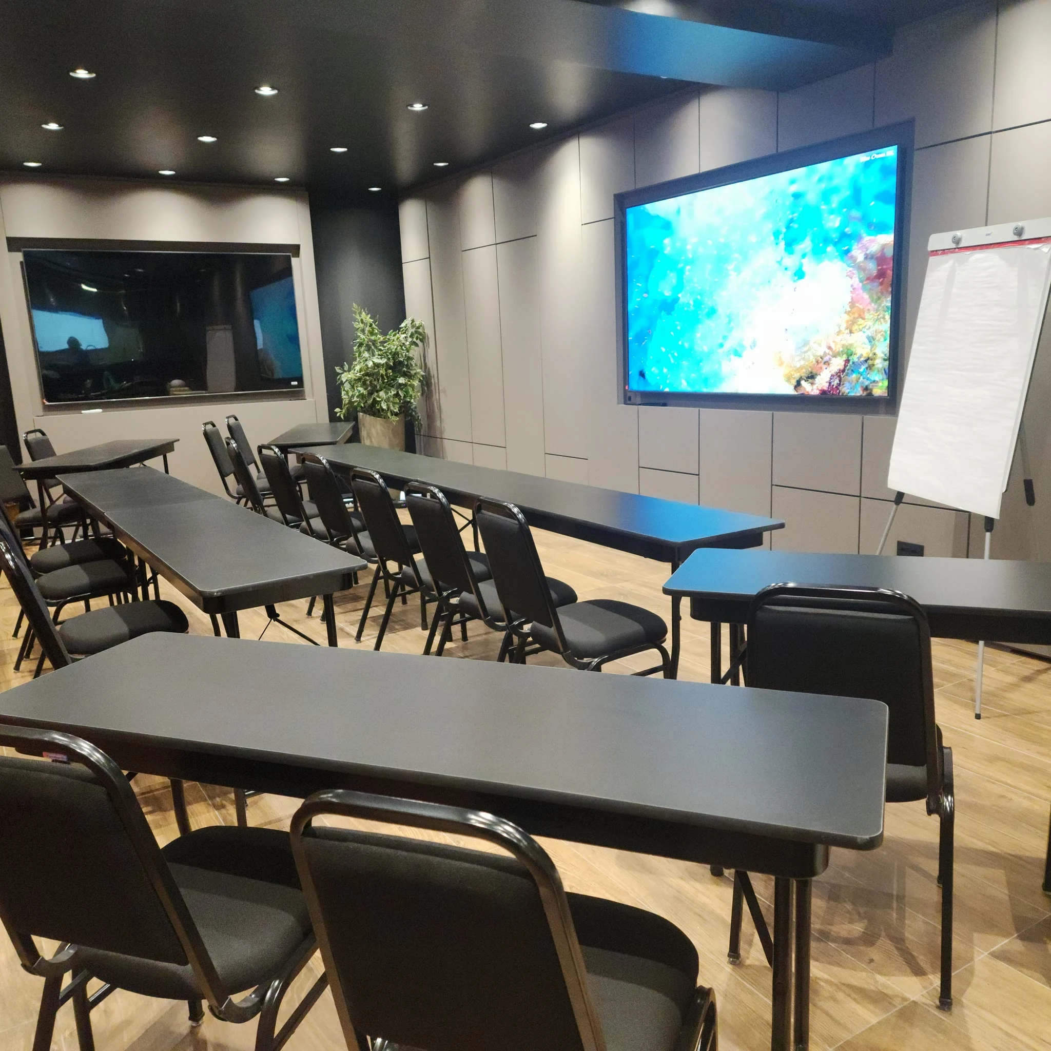 Sala de treinamento corporativo em formato de sala de aula, com cadeiras voltadas para tela de projeção, no Espaço Convivium
