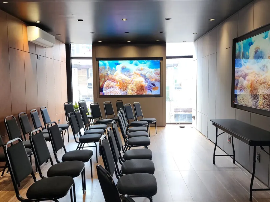 Layout auditório com cadeiras em fileiras voltadas para as TVs