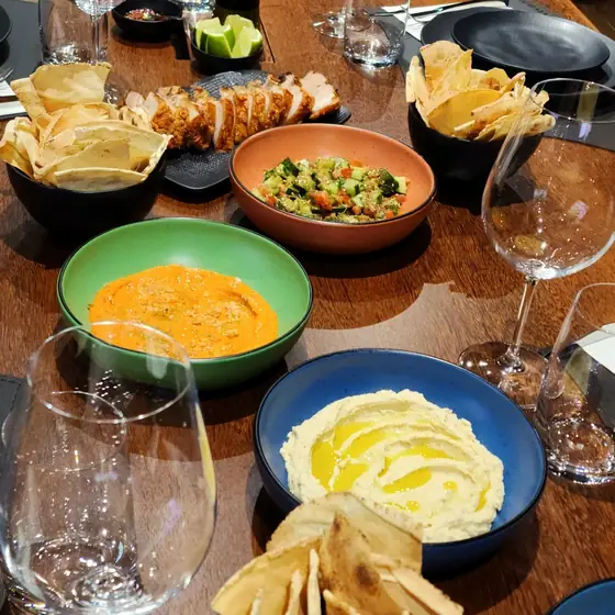 Homus, muhamara, fatuche e pão sírio torrado servidos à mesa no Espaço Convivium